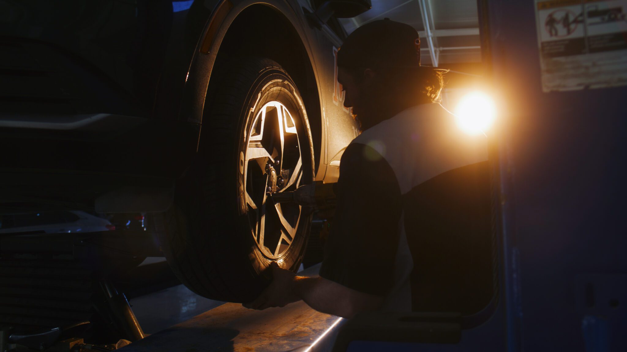 Auto technician performing wheel service and tire installation at Cyclone Tires in Pueblo West, Colorado.